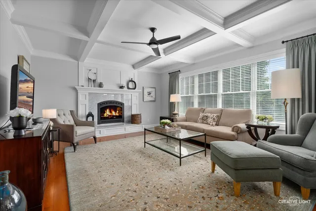 a living room with furniture fireplace and a large window