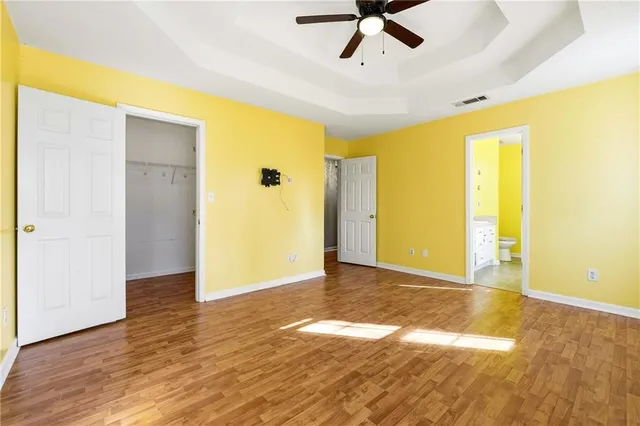a view of a big room with wooden floor and windows