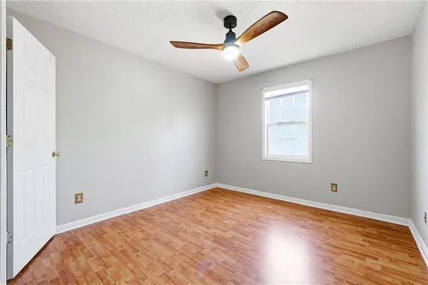 an empty room with a window and a ceiling fan