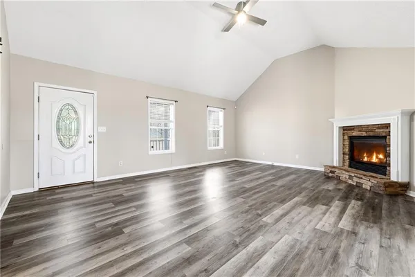 an empty room with windows and fireplace