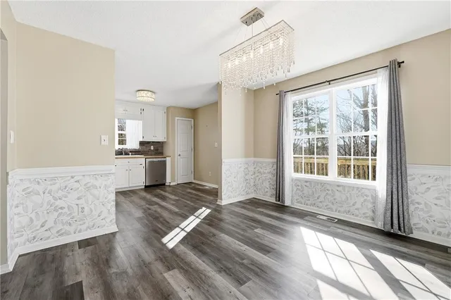 a view of a kitchen with wooden floor and electronic appliances