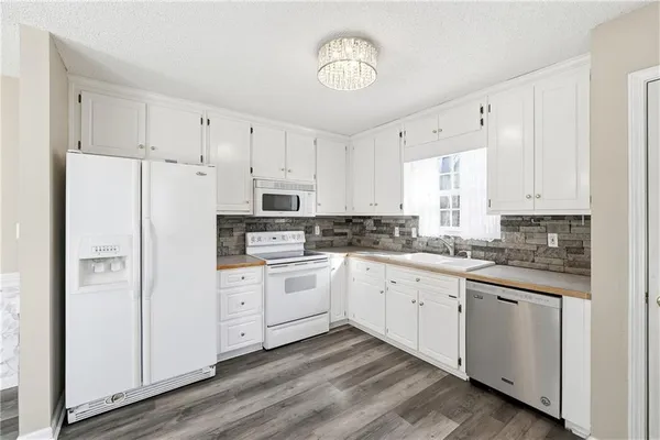 a kitchen with white cabinets and white stainless steel appliances