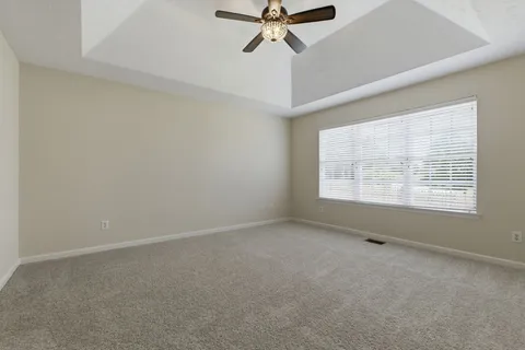 an empty room with a window and a fan