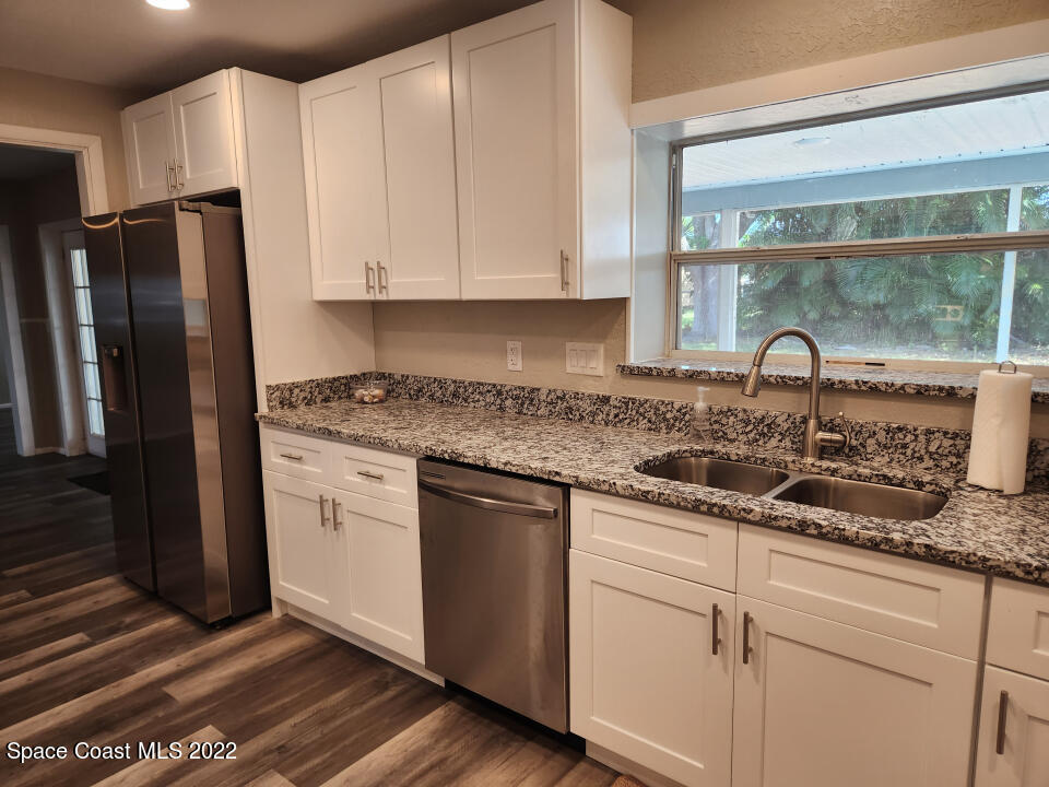 1267 Cotton Road Northeast Palm Bay, FL 32905 - Photo 11 of 30 a kitchen with granite countertop a sink stainless steel appliances and window