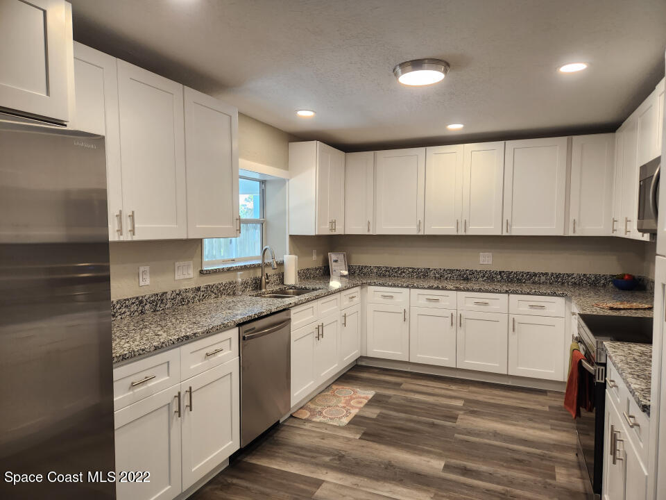 1267 Cotton Road Northeast Palm Bay, FL 32905 - Photo 13 of 30 a kitchen with granite countertop cabinets stainless steel appliances and a counter space
