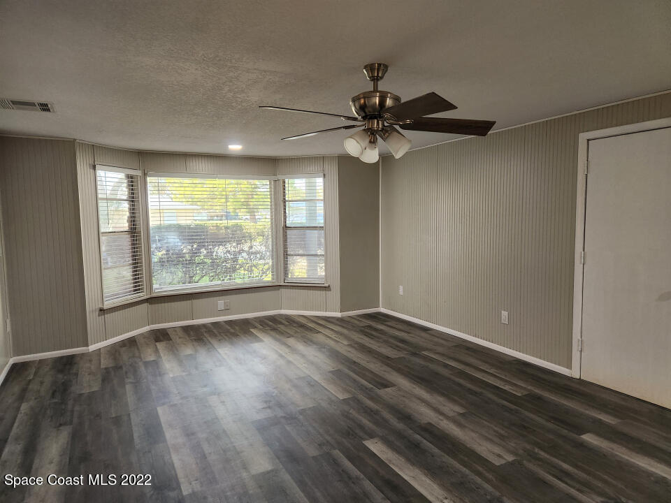 1267 Cotton Road Northeast Palm Bay, FL 32905 - Photo 14 of 30 an empty room with wooden floor fan and windows
