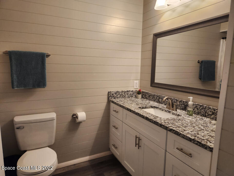 1267 Cotton Road Northeast Palm Bay, FL 32905 - Photo 18 of 30 a bathroom with a granite countertop toilet sink and mirror