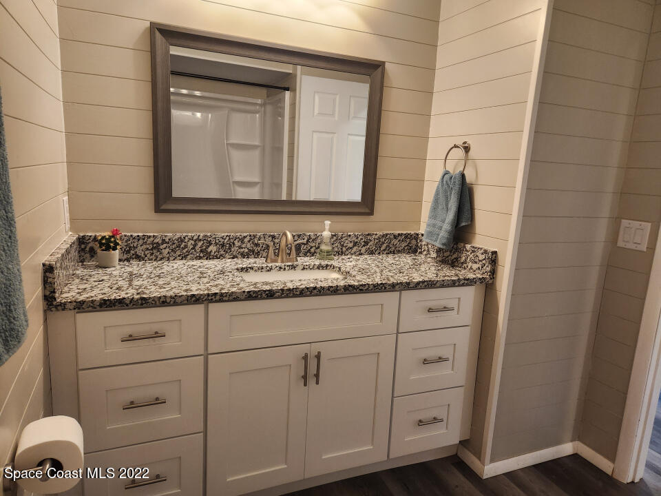 1267 Cotton Road Northeast Palm Bay, FL 32905 - Photo 19 of 30 a bathroom with a granite countertop sink and a mirror