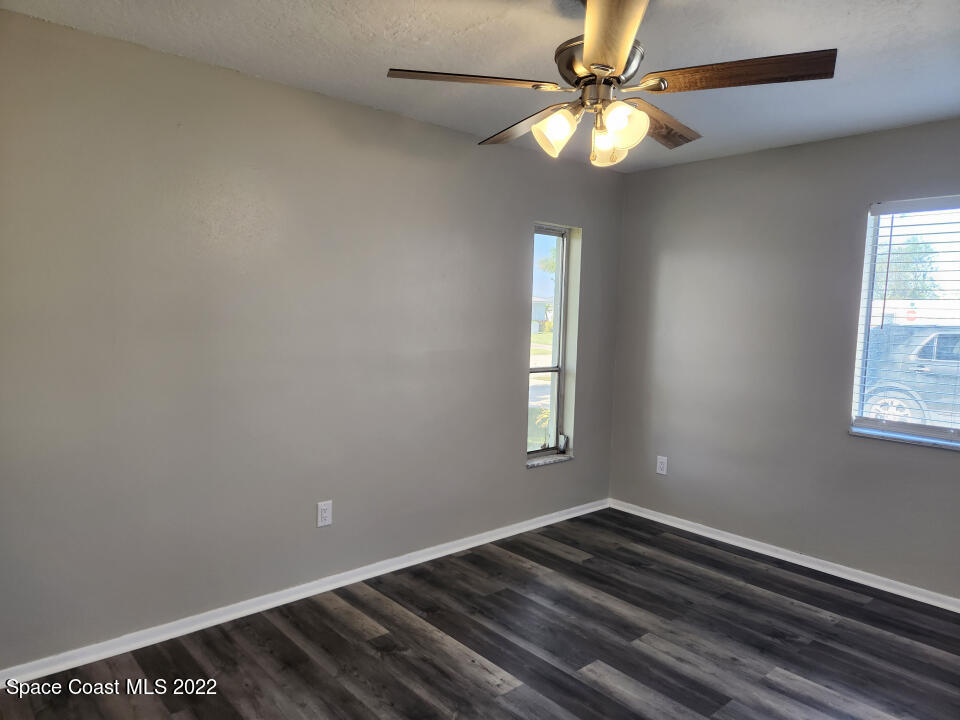 1267 Cotton Road Northeast Palm Bay, FL 32905 - Photo 20 of 30 a view of an empty room with window and chandelier fan