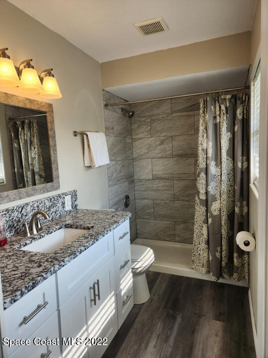 1267 Cotton Road Northeast Palm Bay, FL 32905 - Photo 23 of 30 a bathroom with a granite countertop sink toilet and shower
