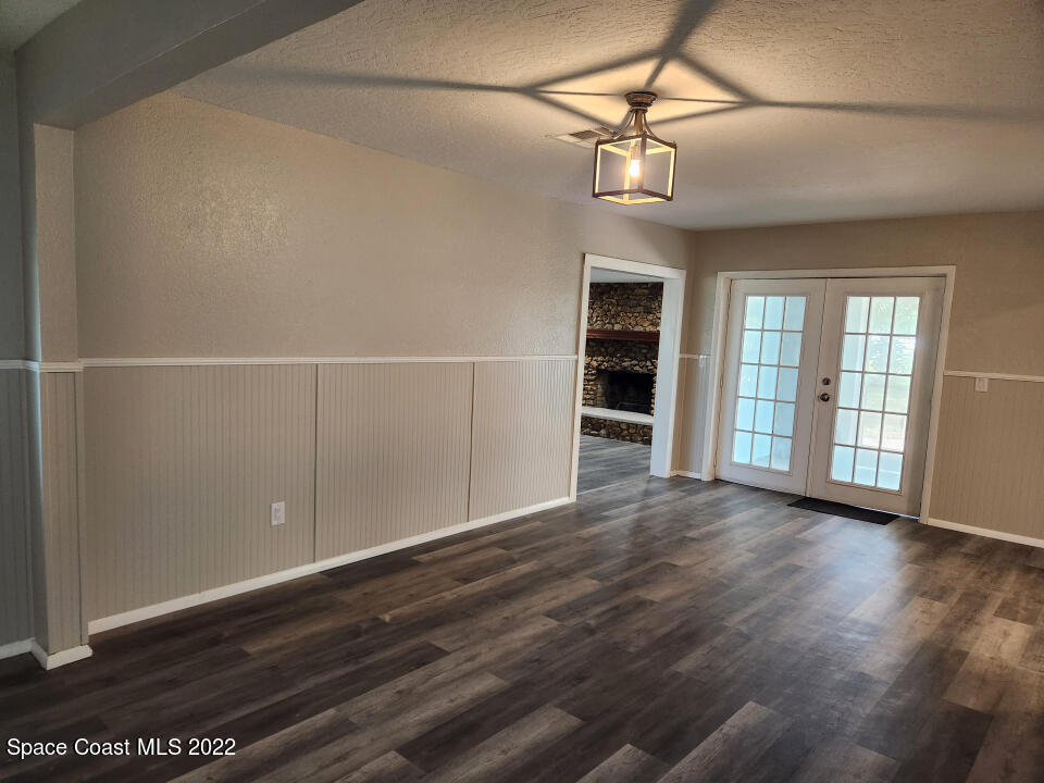 1267 Cotton Road Northeast Palm Bay, FL 32905 - Photo 7 of 30 a view of an empty room with a window and wooden floor
