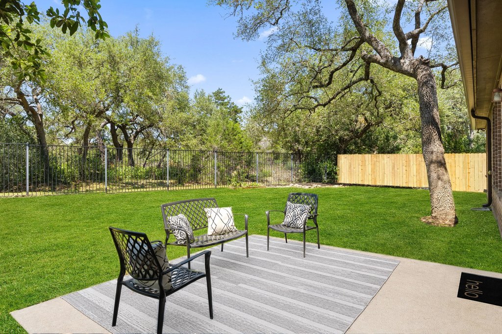 11129 Bastogne Loop Austin, TX 78739 - Photo 27 of 40 The fully fenced backyard offers a large grassy lawn with room for a pool, concrete patio, mature oak trees, wrought iron fencing along the greenbelt, and new privacy fencing and gate on the right.