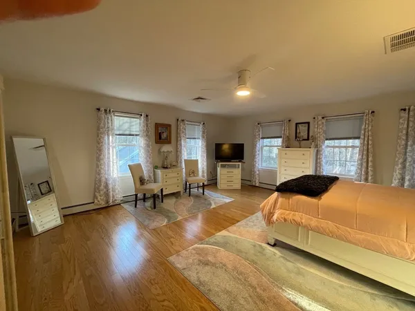 a bedroom with a bed and large windows