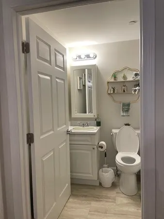 a bathroom with a toilet a sink and mirror