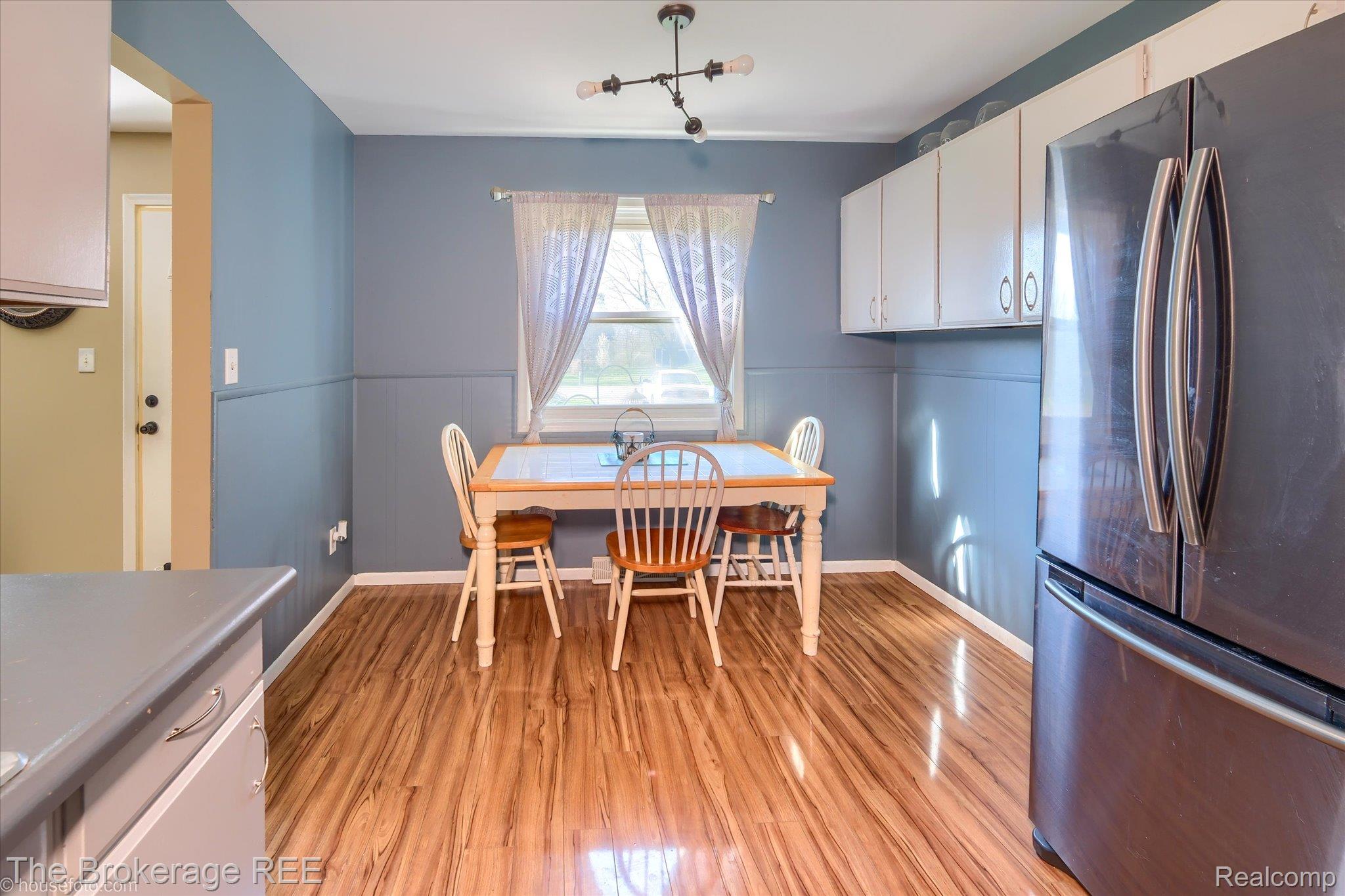 5477 Hopkins Road Flint, MI 48506 - Photo 6 of 27 Dining room with light wood finished floors, a wainscoted wall, and a decorative wall
