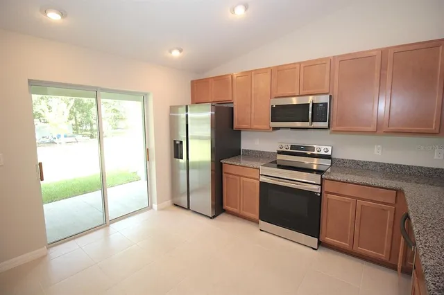 a kitchen with stainless steel appliances a refrigerator stove and microwave