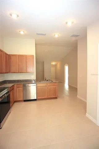 a large kitchen with stainless steel appliances a sink and cabinets