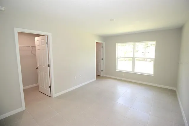an empty room with windows and closet