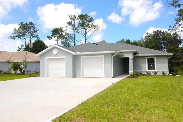 a front view of a house with a garden and yard