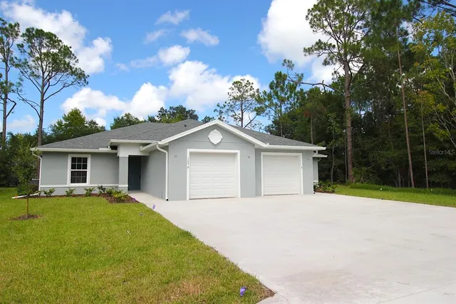 a front view of a house with yard and trees