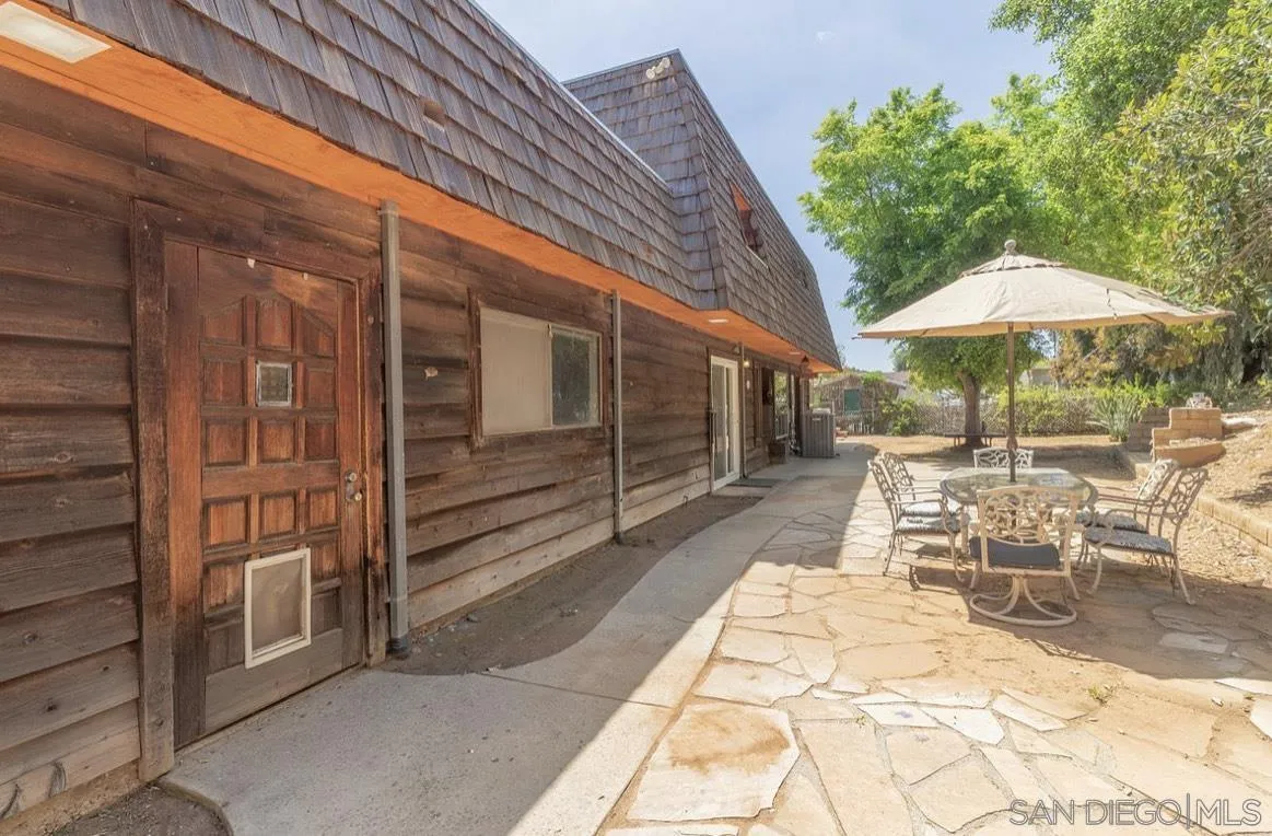 2328 Grace Lane Alpine, CA 91901 - Photo 5 of 27 a view of a patio with a table and chairs under an umbrella with a barbeque