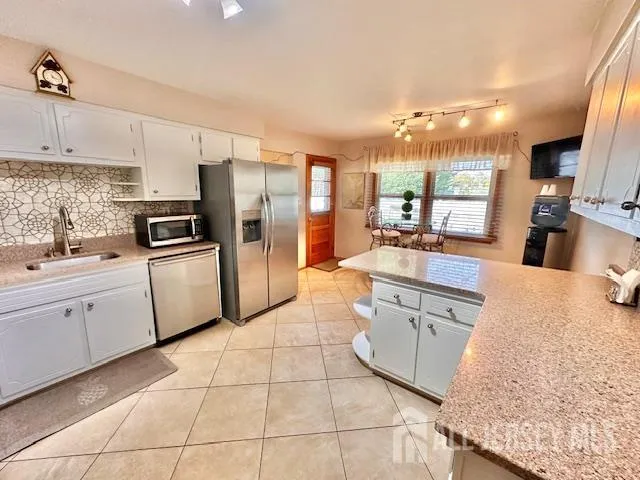 a kitchen with white cabinets appliances and sink
