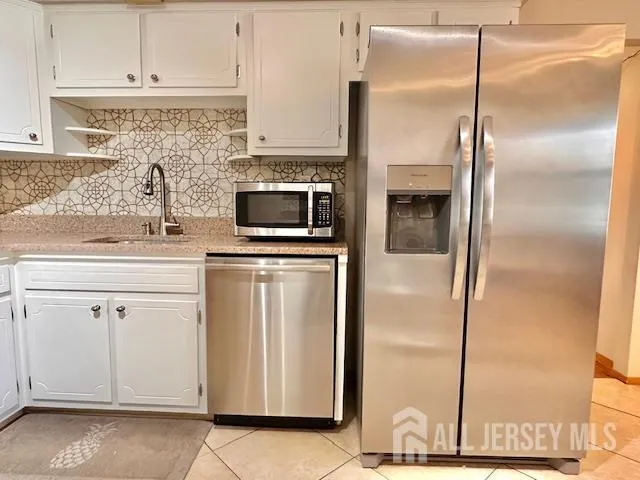 a kitchen with appliances a sink and cabinets