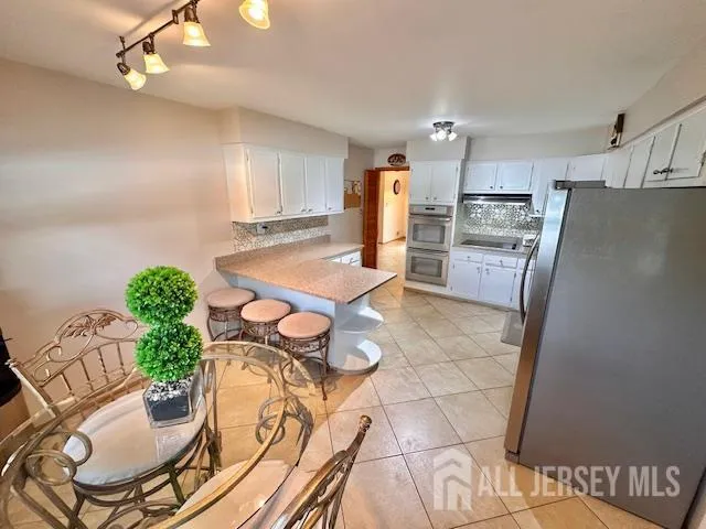 a kitchen with a table chairs stove and refrigerator