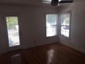 2104 Enfield Road, Unit D Austin, TX 78703 - Photo 3 of 14 Spare room with dark wood-type flooring, a ceiling fan, and plenty of natural light