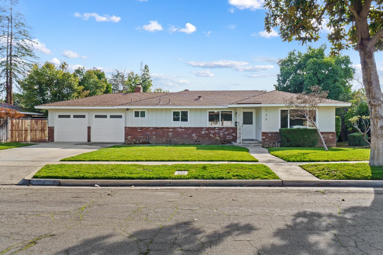 725 West Rialto Avenue Fresno, CA 93705 - Photo 1 of 25 a front view of a house with a garden and trees