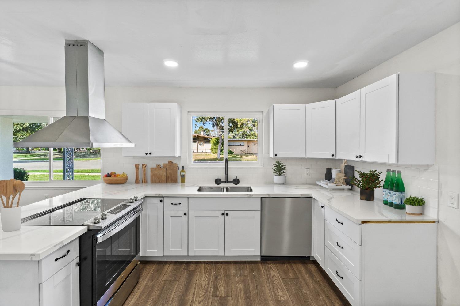 725 West Rialto Avenue Fresno, CA 93705 - Photo 11 of 25 a kitchen with a sink stove cabinets and wooden floor