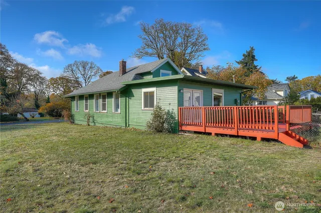 a view of a house with a yard and deck