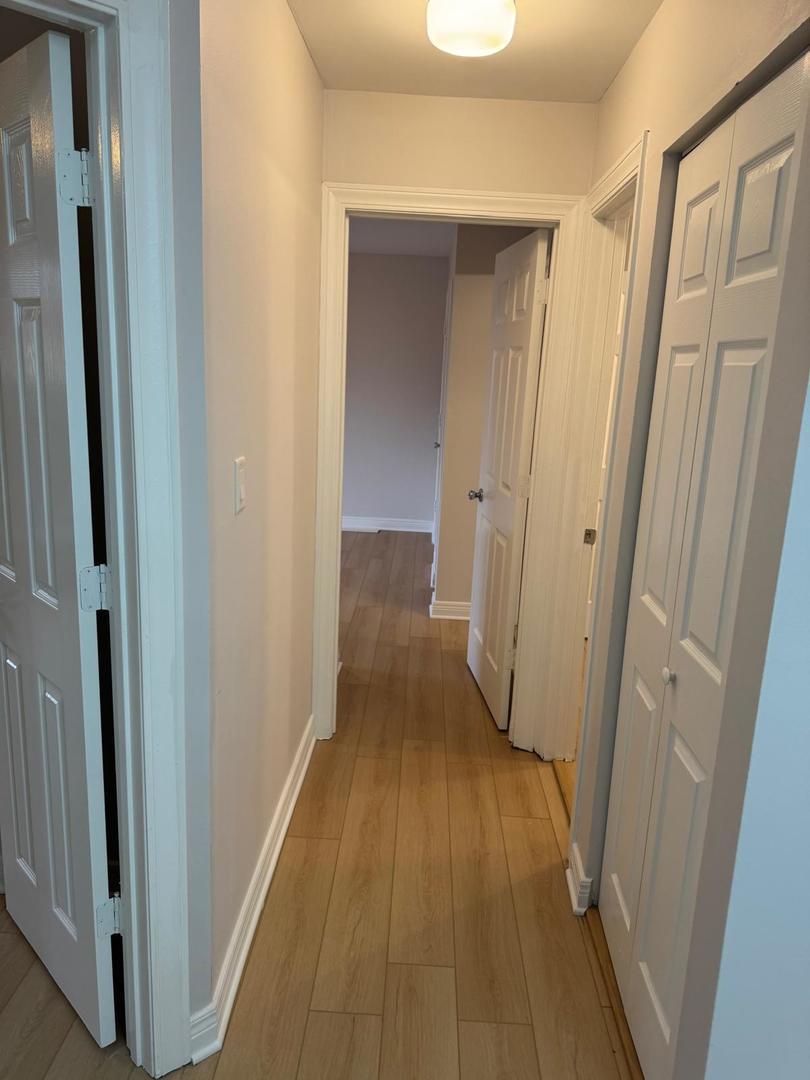 1935 North Hicks Road, Unit 106 Palatine, IL 60074 - Photo 10 of 16 a view of a hallway with wooden floor and a bathroom