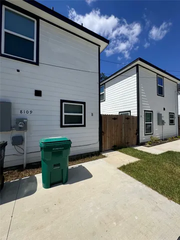 a backyard of a house with barbeque oven and outdoor seating