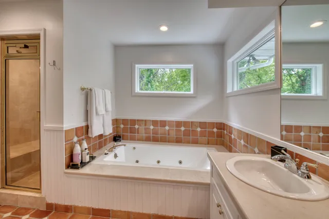 a bathroom with a tub sink and window
