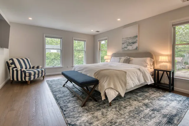 a spacious bedroom with a bed a couch and a window