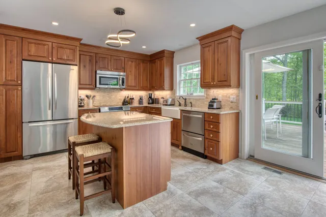 a kitchen with stainless steel appliances granite countertop a stove a sink a refrigerator and a microwave