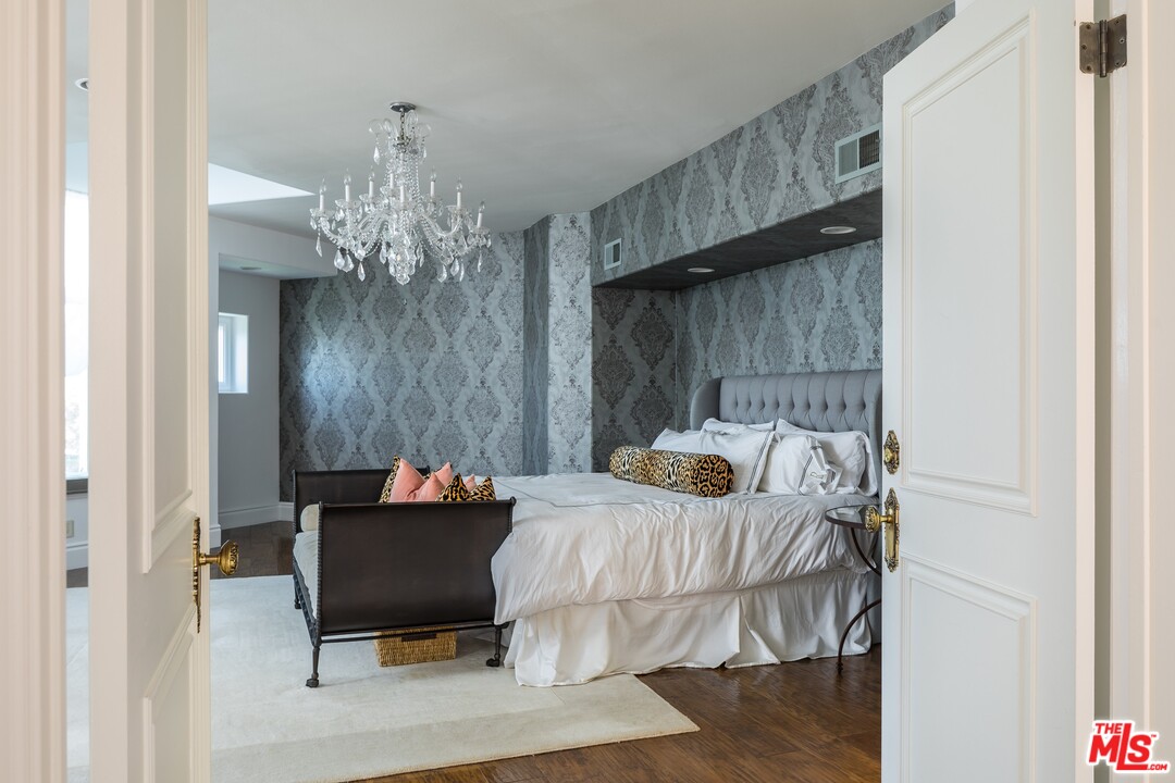 129 Roma Court Marina del Rey, CA 90292 - Photo 21 of 42 a bedroom with a bed and a chandelier