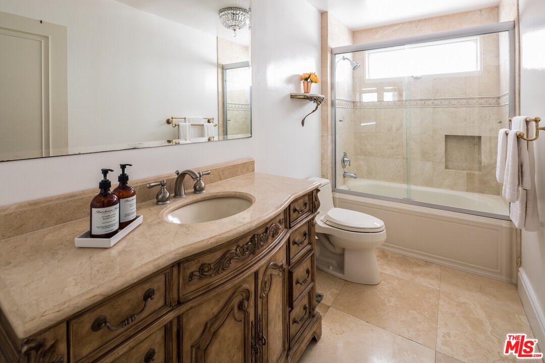 129 Roma Court Marina del Rey, CA 90292 - Photo 32 of 42 a bathroom with a granite countertop sink a toilet a mirror and shower