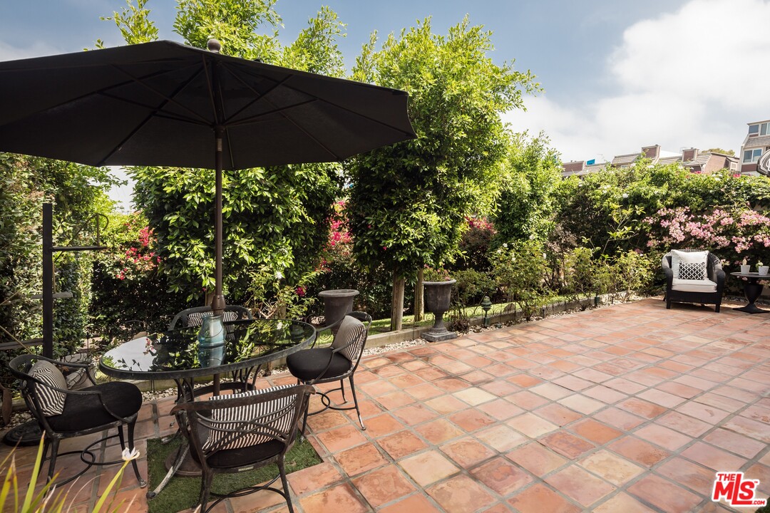 129 Roma Court Marina del Rey, CA 90292 - Photo 41 of 42 a patio with a table and chairs under an umbrella