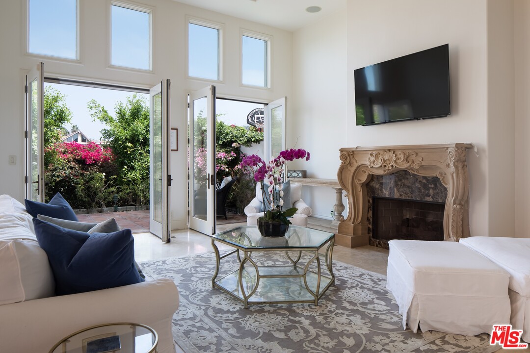 129 Roma Court Marina del Rey, CA 90292 - Photo 7 of 42 a living room with furniture a flat screen tv and a fireplace