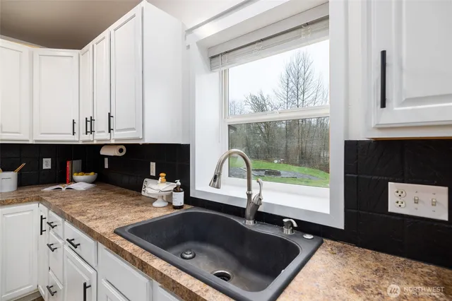 a kitchen with granite countertop a stove a sink and a microwave