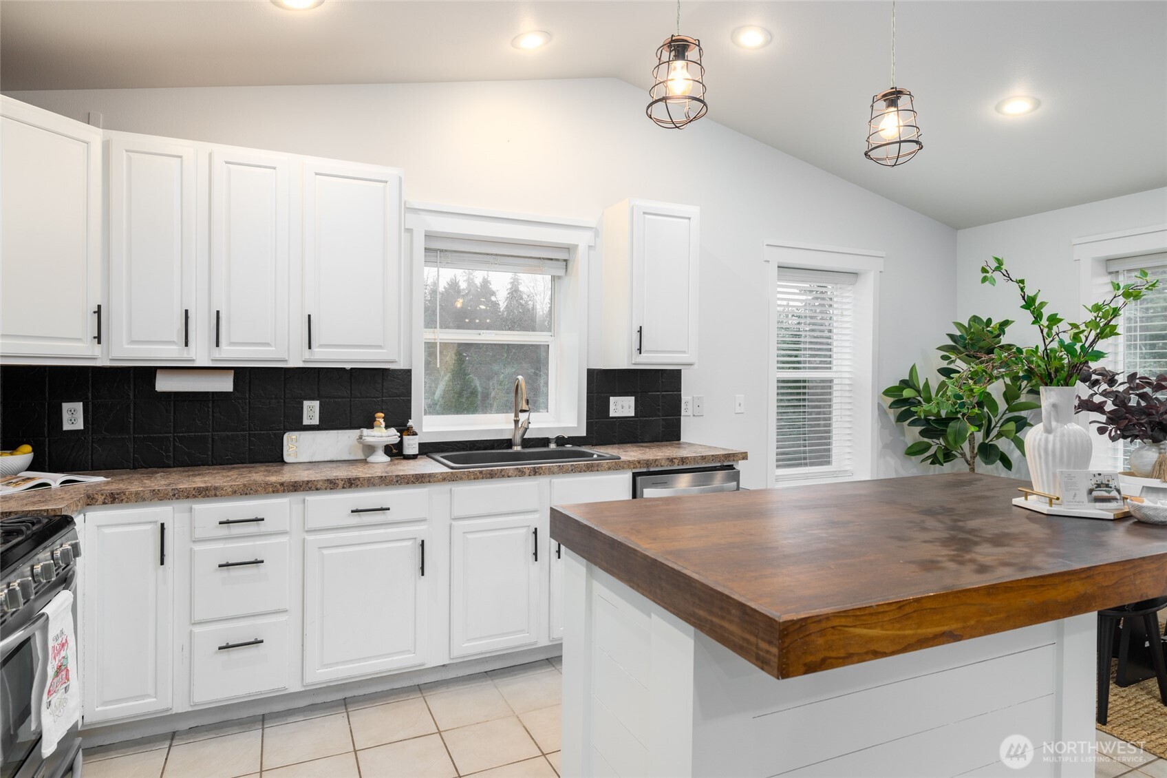 19366 Parson Creek Road Burlington, WA 98233 - Photo 12 of 31 a kitchen with granite countertop a sink white cabinets and black appliances
