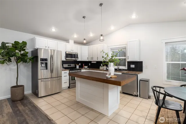 a kitchen with refrigerator and chairs