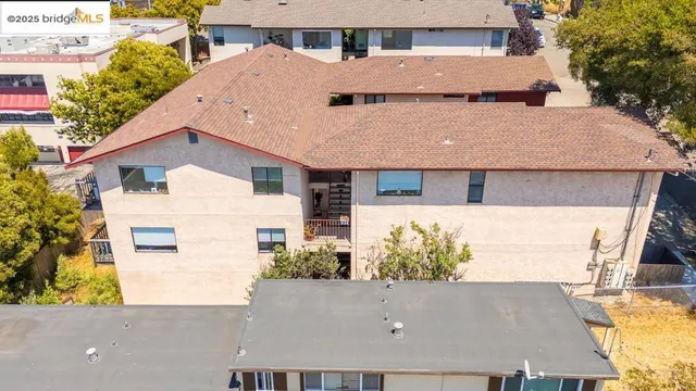 an aerial view of residential houses with outdoor space and parking