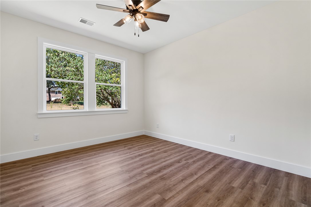 1507 Tindall Avenue Anderson, SC 29621 - Photo 25 of 38 Rich wood-inspired flooring pairs with generous windows framing leafy outdoor views.