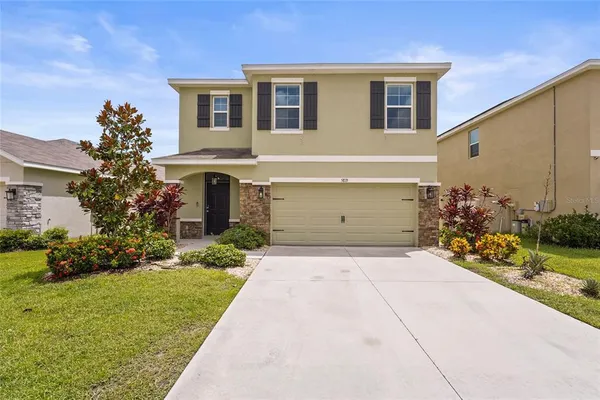 a front view of a house with a yard and garage