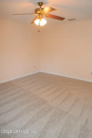 en empty room with wooden floor and fan