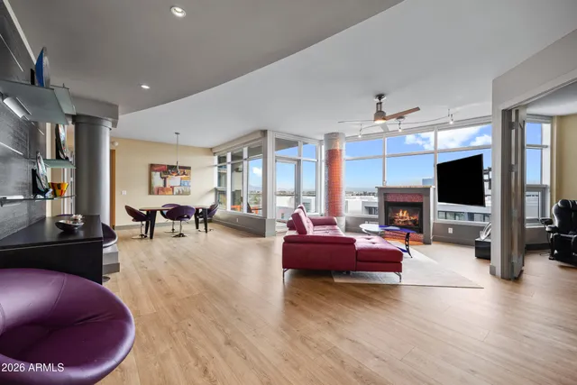 a living room with furniture a flat screen tv and a large window