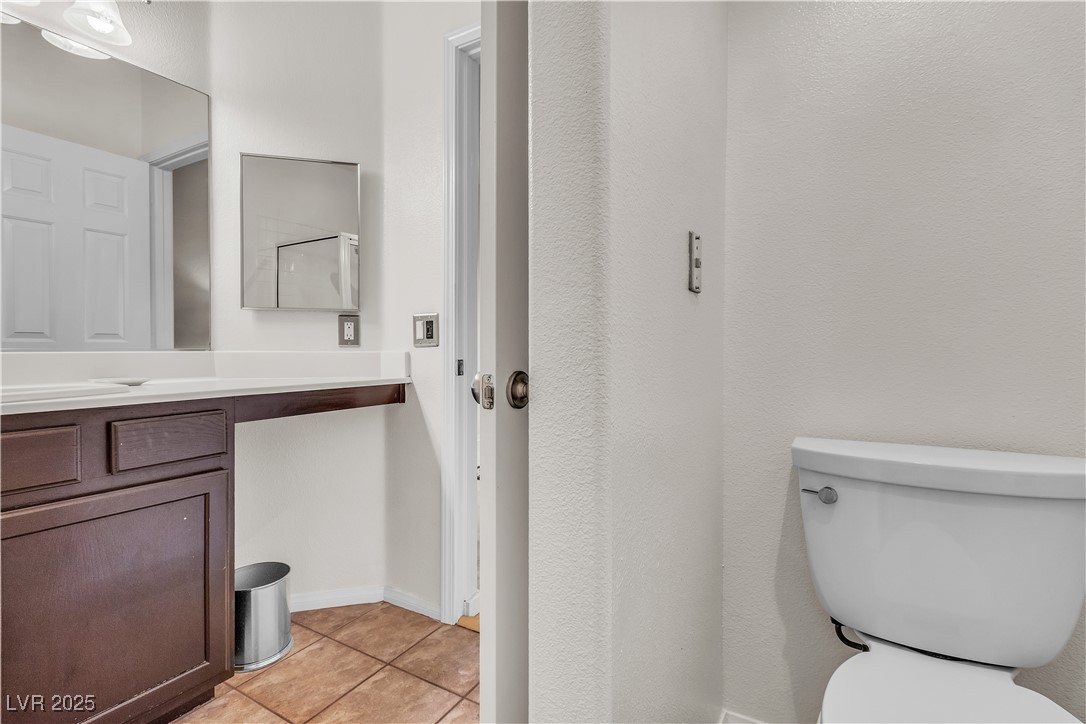 2050 West Warm Springs Road, Unit 1822 Henderson, NV 89014 - Photo 18 of 55 Bathroom featuring toilet, tile patterned floors, and vanity. Under counter space for trash can or makeup stool.